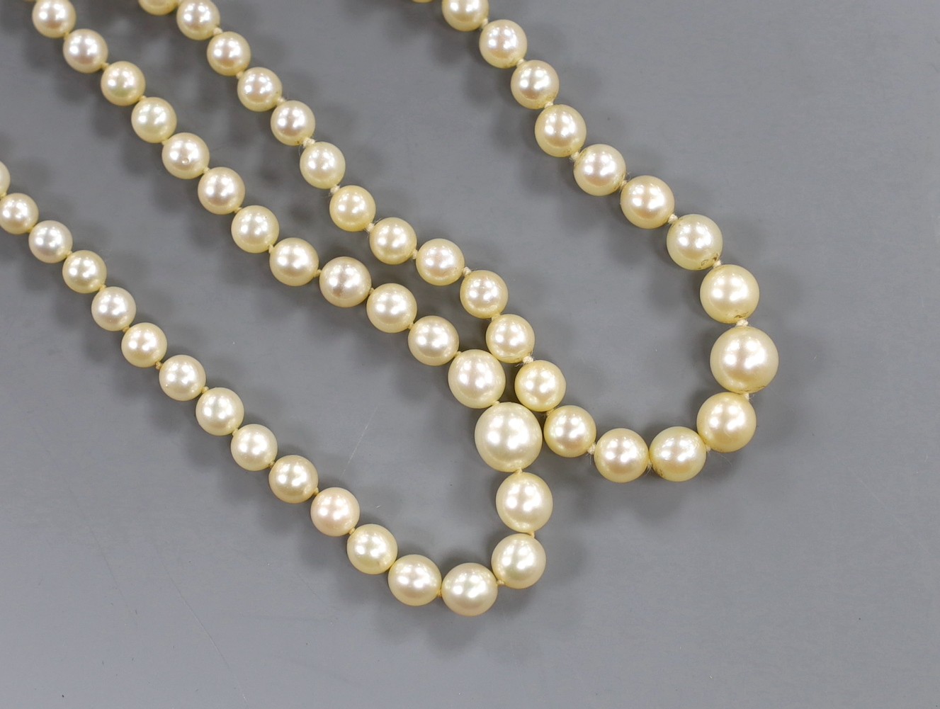 Two single strand graduated cultured pearl necklaces, both with diamond set clasps, one stamped 9ct and plat, longest 48cm.